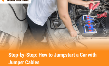 Person connecting red jumper cable to car battery terminal while jumpstarting a vehicle, showing safe and proper jumper cable use