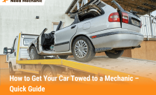 Tow truck loading a damaged car onto a flatbed, showing how to get your car towed to a mechanic safely and quickly.